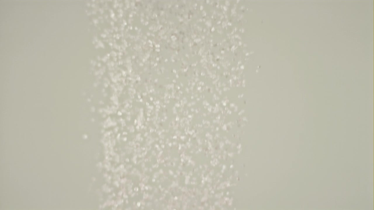 Slow Motion Falling Glitter Particles on a Light Background