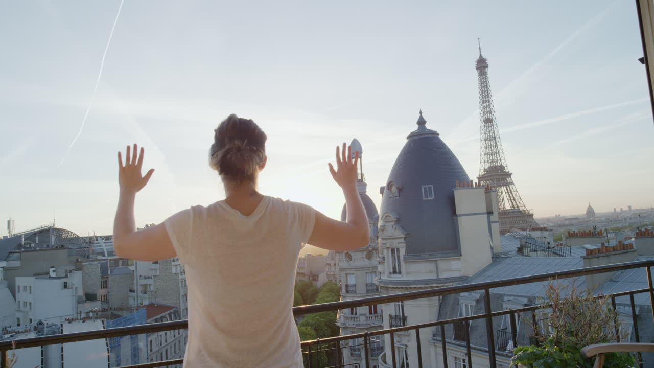 donna che usa un auricolare di realtà virtuale che si gode di esplorare l'esperienza del cyberspazio online sul balcone della bellissima torre eiffel al tramonto di parigi