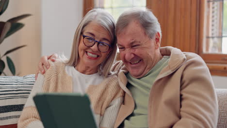 Tablet,-laugh-and-senior-couple-on-a-sofa-watching