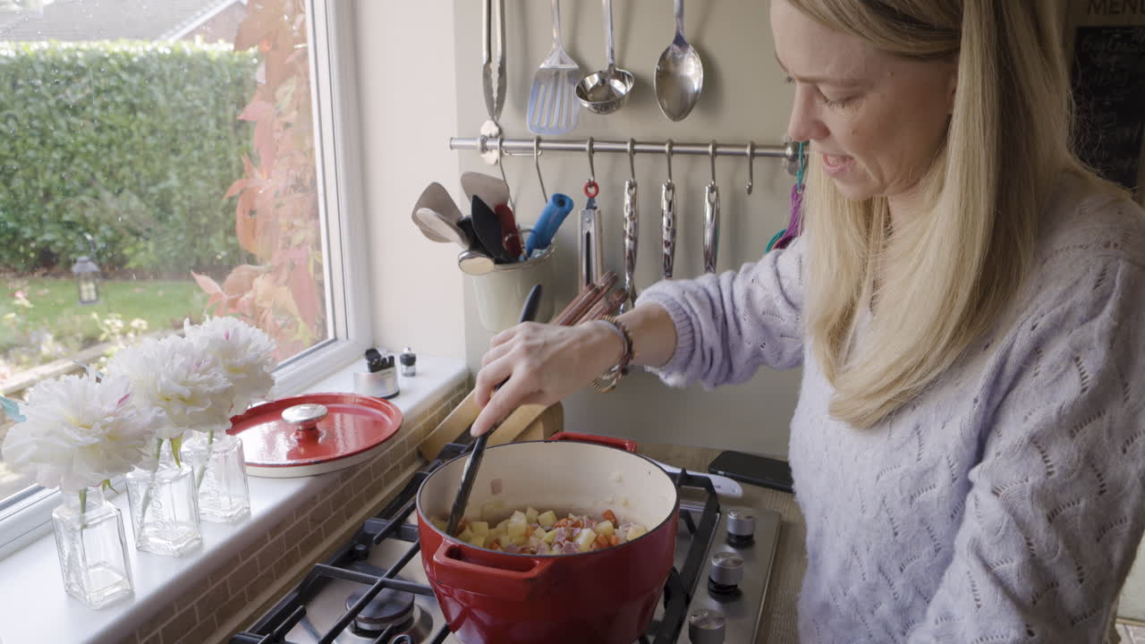 Woman cooking food in pot on stove