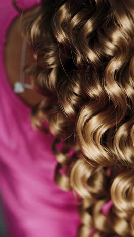 close-up of a child with curly hair and a heart-shaped necklace.