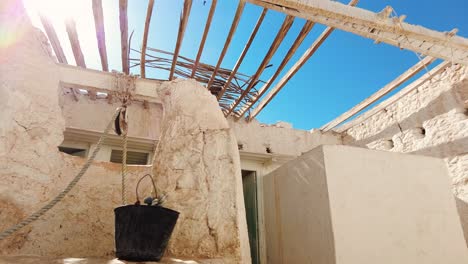 casa vieja con un pozo en el medio del desierto