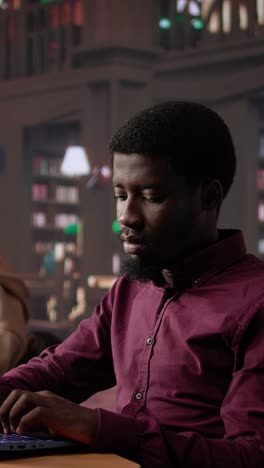 vertical video black male student collecting academic information from the campus library