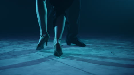 closeup dancers legs dancing indoors. partners feet doing latin dance steps.