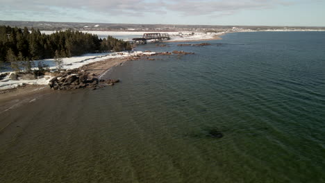 drone flight over the ocean in winter with snow in chandler, quebec, canada