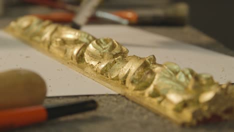 polishing a gold leafed piece of furniture