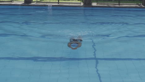 Un-Joven-Usa-Gafas-De-Natación,-Bucea-Y-Nada-Al-Estilo-Rana-En-La-Piscina