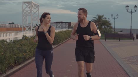 pareja corriendo juntos por un camino de la playa