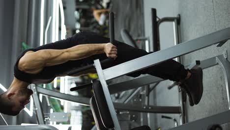 Athlete-man-training-force-push-up-and-pull-up-exercise-on-bars-in-gym