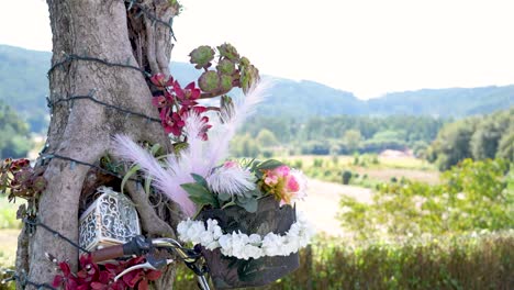 floral arrangement with white, green, and red leaves in the wind in an outdoor garden with a beautiful view
