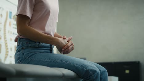 Unrecognizable-caucasian-woman-sitting-on-medical-bed-and-feeling-very-stressed