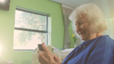 Animation-of-glowing-light-over-happy-senior-woman-using-smartphone