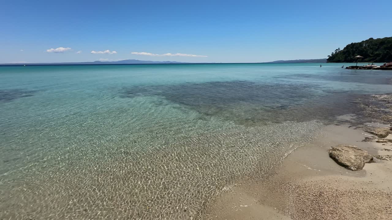 Stunning beach scene in Halkidiki, Greece, with elegant sunbeds facing the crystal-clear turquoise sea. A perfect summer escape in the heart of the Aegean.