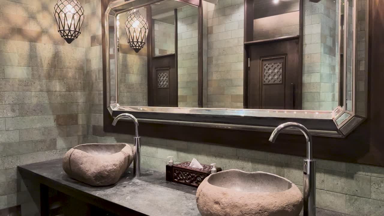 Elegant stone sink and modern fixtures in a luxury resort bathroom, featuring ambient lighting and sophisticated design elements
