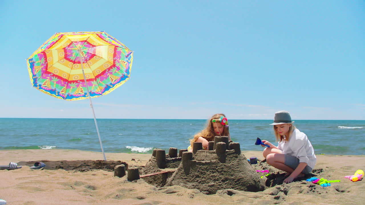 Дети строят песчаные замки на пляже.