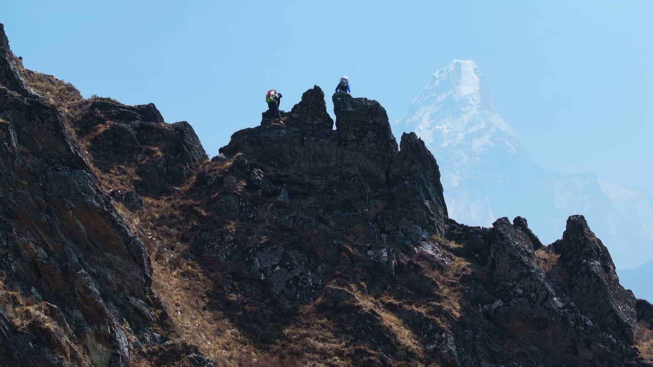Tourists trek from Phortse to Dingboche, climbing rocky hills on Everest Base Camp trail. Dreamy mountainscape creates iconic Nepali scenery Tourism travel drone shot