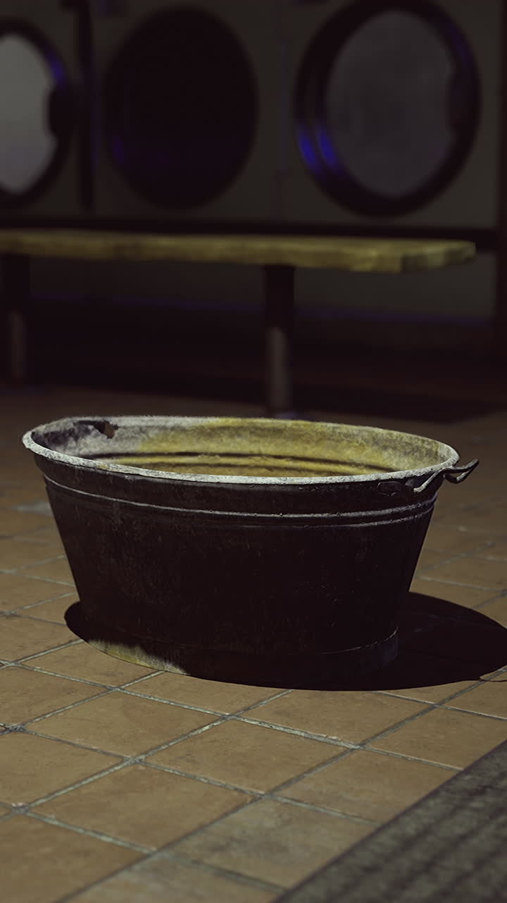 Bucket sitting alone in a dimly lit laundromat during late night hours