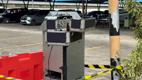 outdoor air quality monitoring station installed in a parking lot, showing exposed gas analysis instruments and tubing used for environmental pollution measurement. impinger and hvas machine