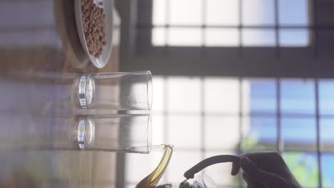 female hand pours hot black coffee into two glasses and peanuts served in plate | vertical video