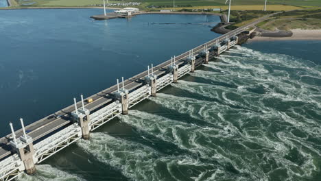 vehículos que conducen en el puente de la carretera de la presa de la barrera contra la marejada ciclónica del este de scheldt cerca de kamperland, zelanda