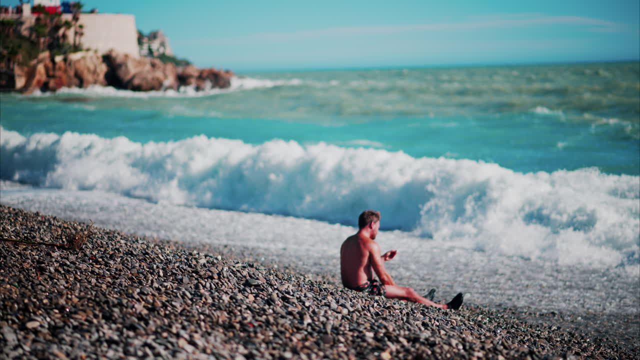 Man relaxing on the beach while Waves hitting the shore in Cannes, France