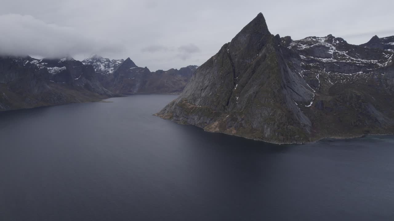 vista aérea con vistas al reinefjord, en nublado, lofoten, noruega - pan, drone shot