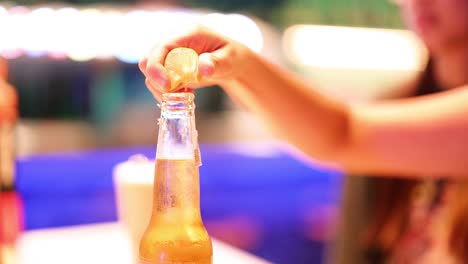 hand squeezing lemon into a beer bottle