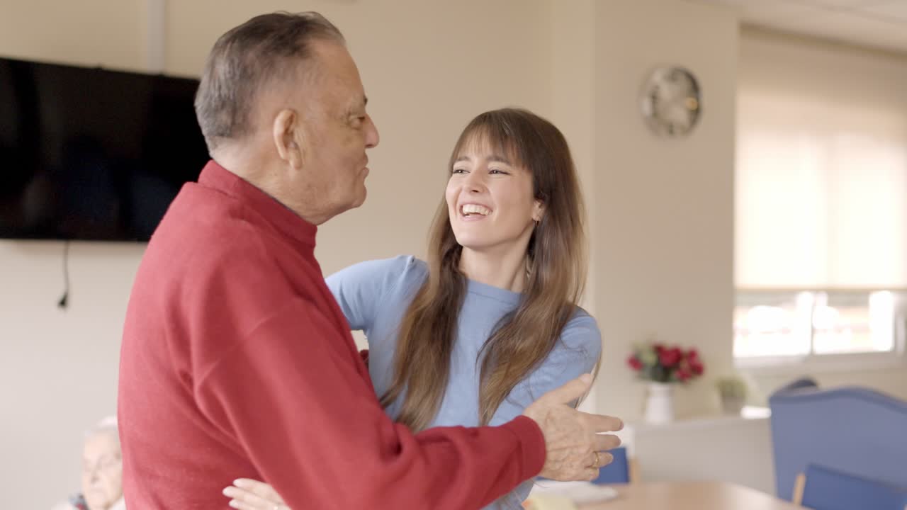 Happy grandfather receiving the visit of his granddaughter in geriatric