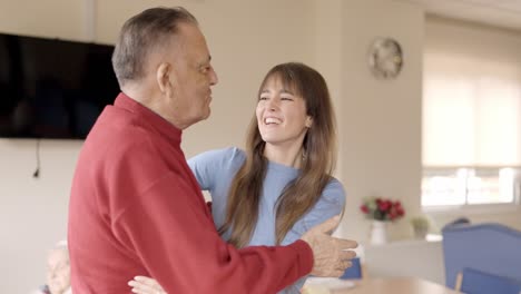 happy grandfather receiving the visit of his granddaughter in geriatric