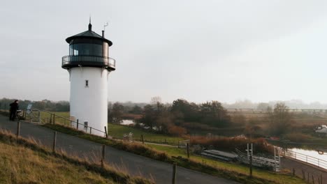 Der-Kameraschwenk-Zeigt-Den-Leuchtturm,-Während-Der-Zug-Durch-Den-Hintergrund-Fährt