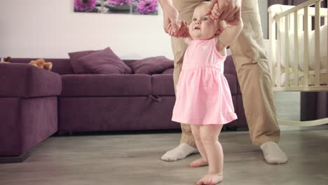 Baby-learning-walk.-Child-learning-to-walk.-Dad-holding-kid-and-teach-steping