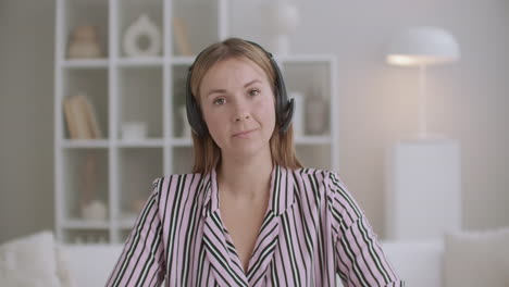 young woman is listening and nodding looking at camera video calling by internet portrait of female participant