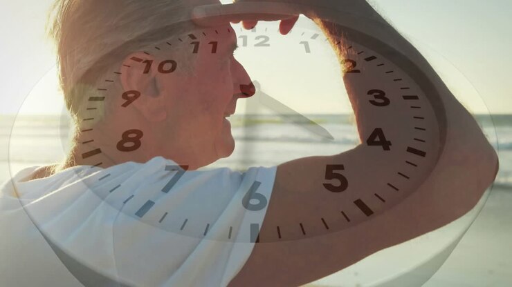 Uomo anziano che si ripara dal sole, scruta il mare, con una debole sovrapposizione di un orologio che segna il passare del tempo per la salute.