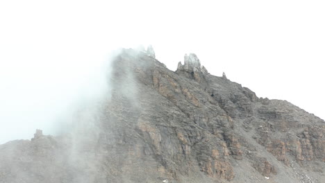 moviéndose hacia la cima de la montaña rocosa cubierta de niebla
