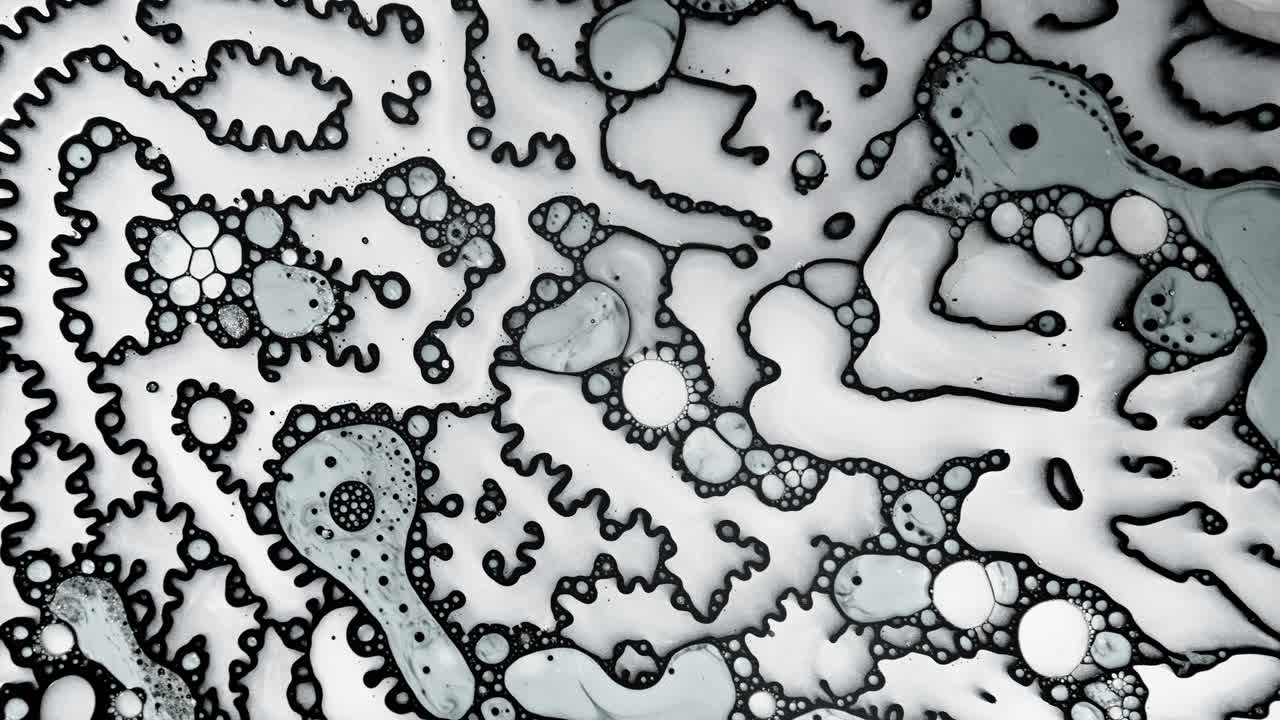 Abstract macro shot of black and white liquid patterns forming intricate organic shapes