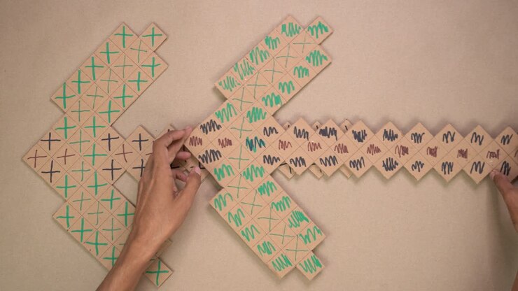 Overhead video of hands assembling and decorating pixel-style cardboard pickaxe for DIY craft activity