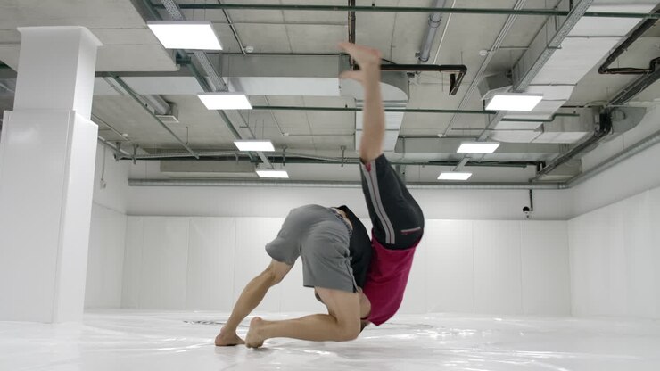 Two wrestlers perform in slow motion. Greco-Roman wrestlers train in the hall in T-shirts and coats
