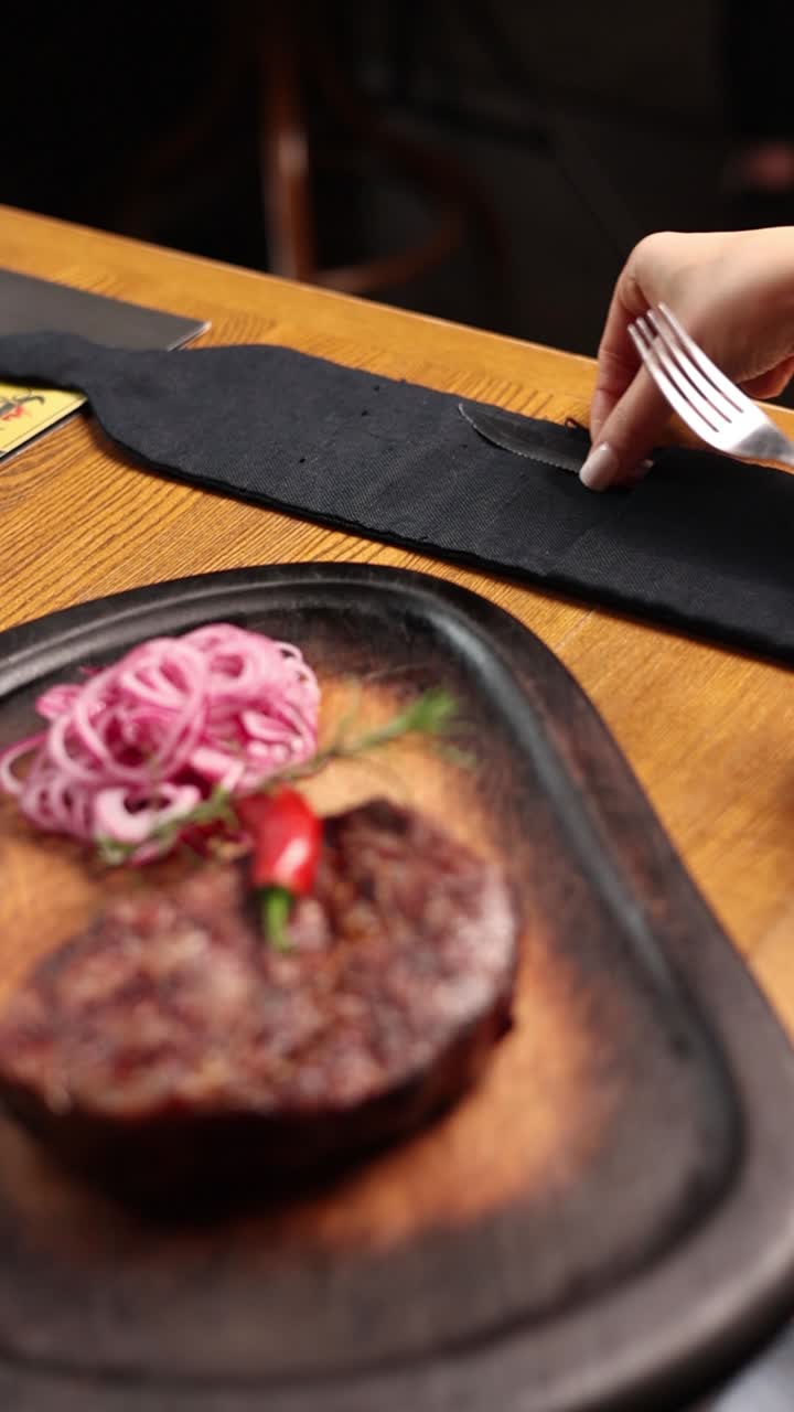 Woman Eating Steak in a Restaurant