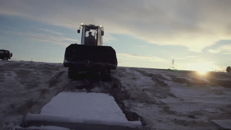 tractor removing snow in winter landscape