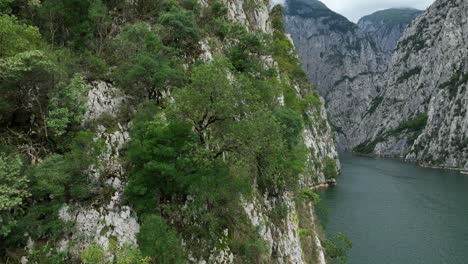 drone shot of lake komani limestone cliffs, narrow canyons carved by drini river, albania