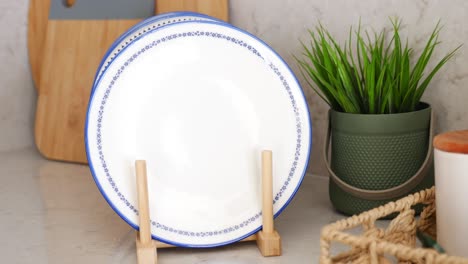 blue and white plates on a wooden stand in a kitchen