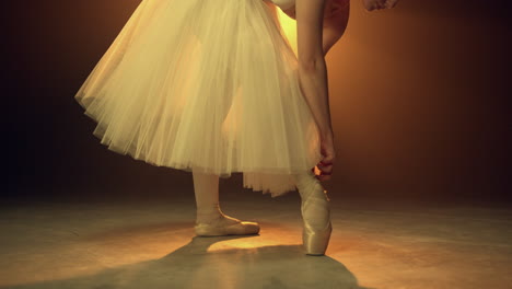 Ballerina-Bindet-Ballettschuhe-Drinnen.-Flexible-Tänzerin,-Die-Sich-über-Spitzen-Beugt