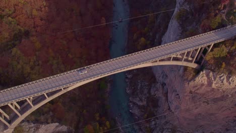 Auto-überquert-Die-Tara-Brücke-Mit-Morgensonne-über-Dem-Tapa-Fluss,-Luftaufnahme