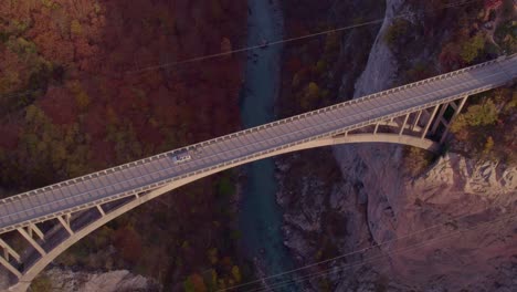 car crossing tara bridge with morning sunshine above tapa river, aerial