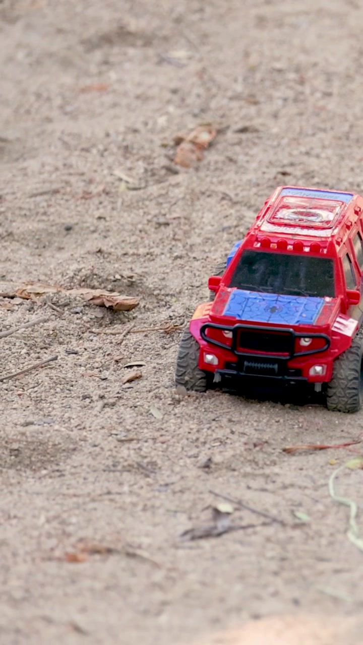 Bambino che gioca con un'auto giocattolo all'aperto