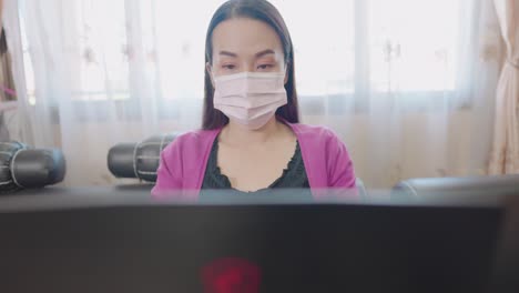 소파에 앉아서 집에서 온라인 쇼핑을 위해 컴퓨터 노트북으로 정보를 입력하는 여성