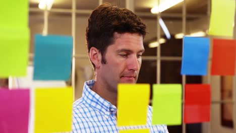 male business executive looking at sticky notes