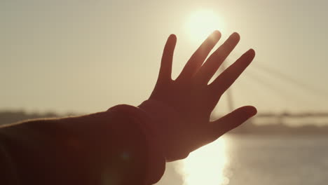 Girl-hand-silhouette-in-golden-sunlight-closeup.-Dreamy-romantic-mood-concept