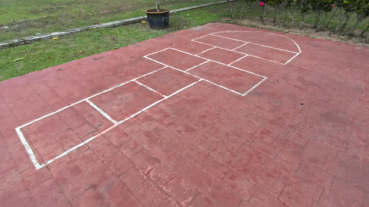 A hopscotch court is painted on the ground. This traditional children’s game is popular worldwide, with different names and slight variations in play