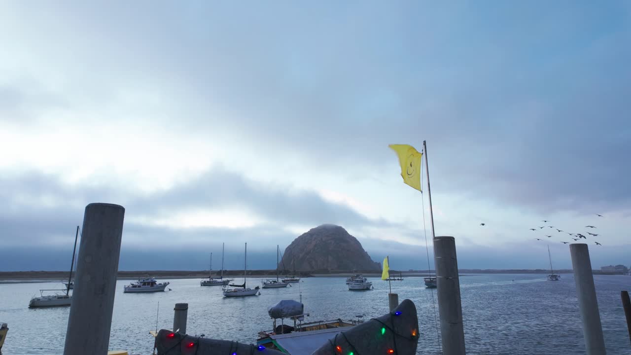 Gimbal close-up booming down shot of a whale tail sculpture decorated in christmas lights at sunset in Morro Bay, California. 4K